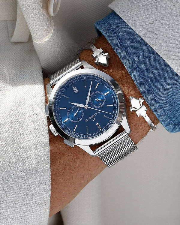  En rund herrklocka i rodiumpläterat silver från WALDOR & CO. med blå sunray urtavla och en sekundvisare. Seiko urverk. Modellen är Chrono 44 Sardinia 44mm. 