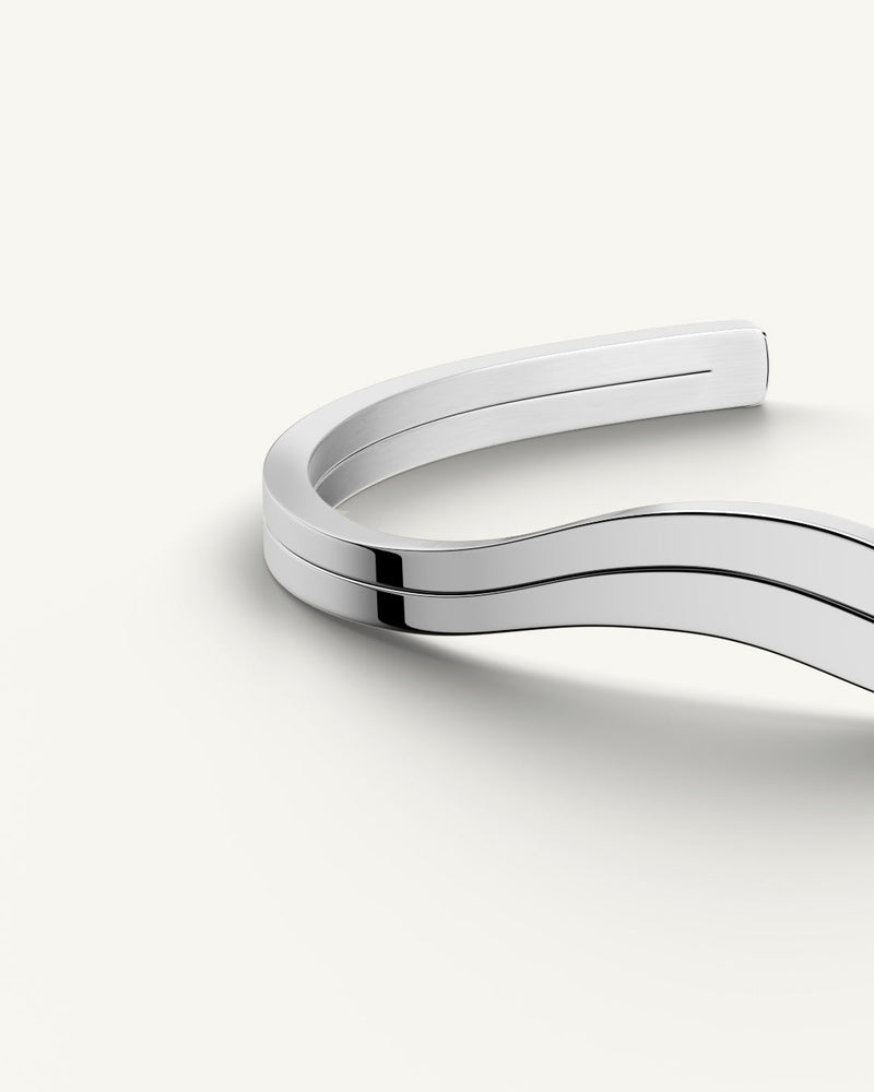 A polished stainless steel bangle in silver from Waldor & Co. One size. The model is Azur Bangle Polished.