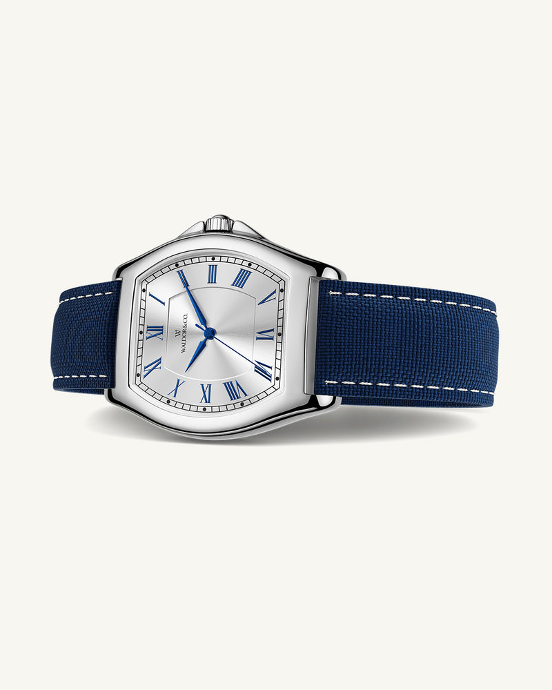 A square mens watch in Rhodium-plated 316L stainless steel from Waldor & Co. with white dial. Blue sailcloth strap. Ronda movement. The model is Constant 40 Tremezzo 37x45mm.