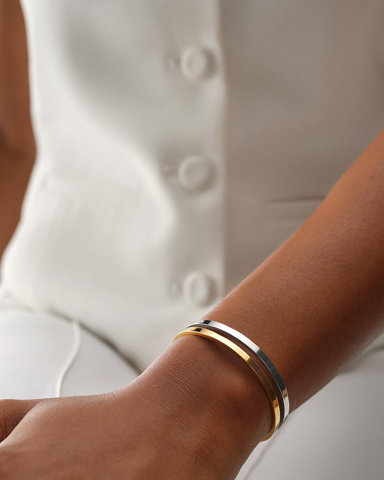 A bangle in 14k gold-plated 316L stainless steel from Waldor & Co. One size. The model is Dual Bangle Polished.