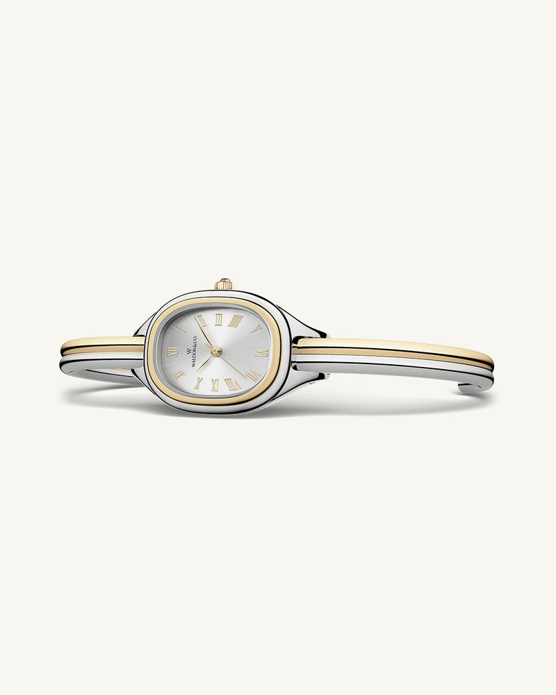 An ellipse shaped womens watch in Rhodium-plated 316L stainless steel from Waldor & Co. with silver sunray dial in brass. Mineral glass with sapphire crystal coating. Seiko movement. The model is Dual Bangle Watch.