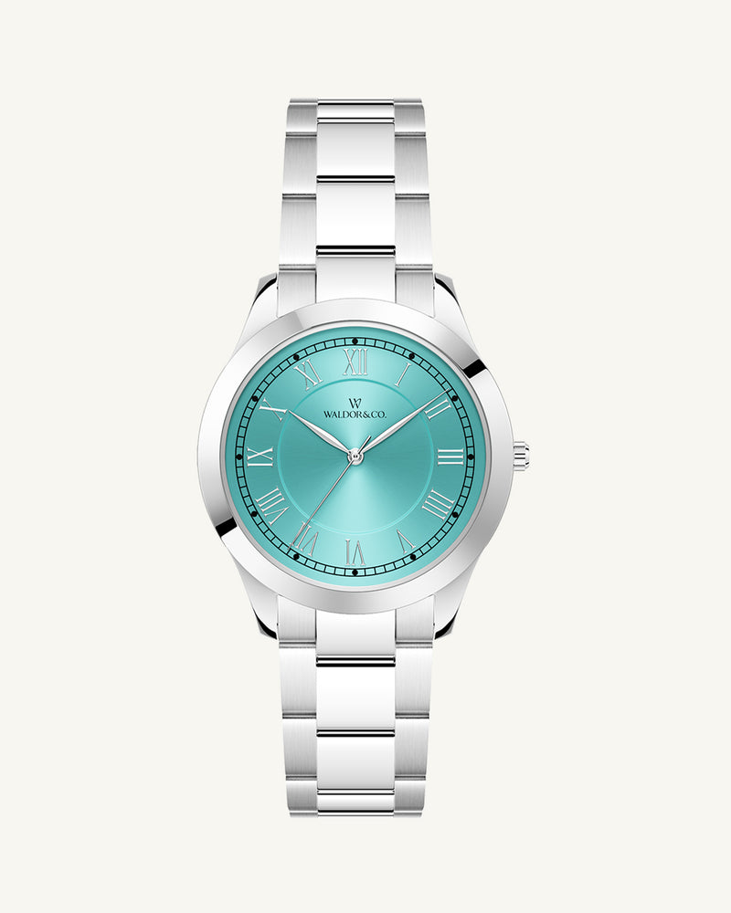 A round womens watch in silver from Waldor & Co. with turquoise sunray dial and a second hand. Seiko movement. The model is Imperial 32 Nocelle 32mm.