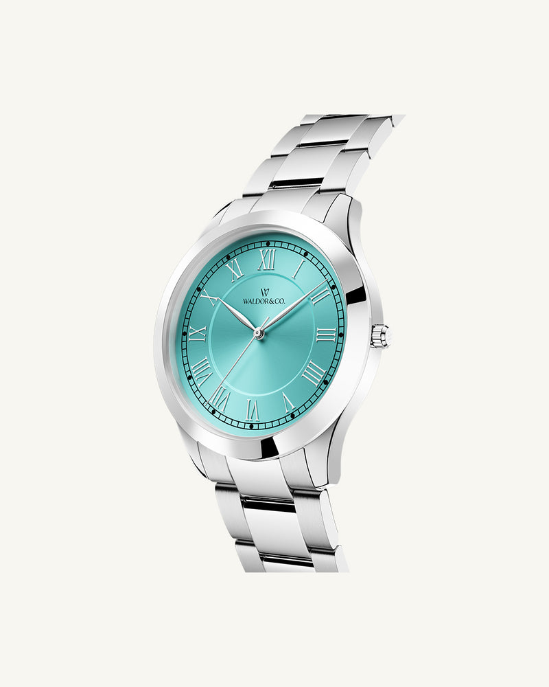 A round womens watch in silver from Waldor & Co. with turquoise sunray dial and a second hand. Seiko movement. The model is Imperial 32 Nocelle 32mm.