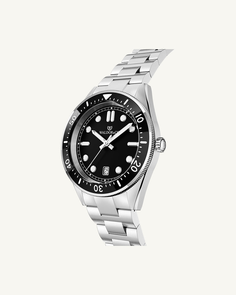 A round mens watch in Rhodium-plated 316L stainless steel from Waldor & Co. with Black dial in brass with a rotating bezel. Applied indices, luminous hands. Ronda 715. The model is Novel 40 Cap d’Ail 40mm.