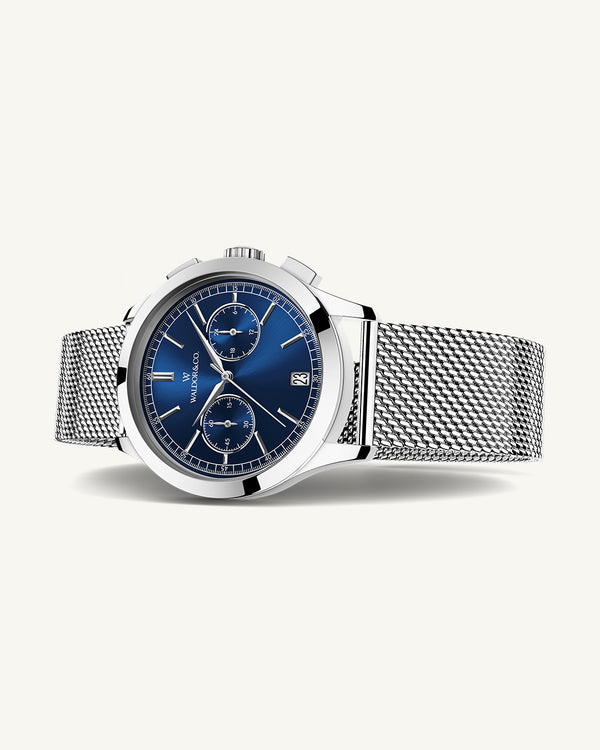 En rund herrklocka i rodiumpläterat silver från WALDOR & CO. med blå sunray urtavla och en sekundvisare. Seiko urverk. Modellen är Chrono 39 Sardinia 39mm. 