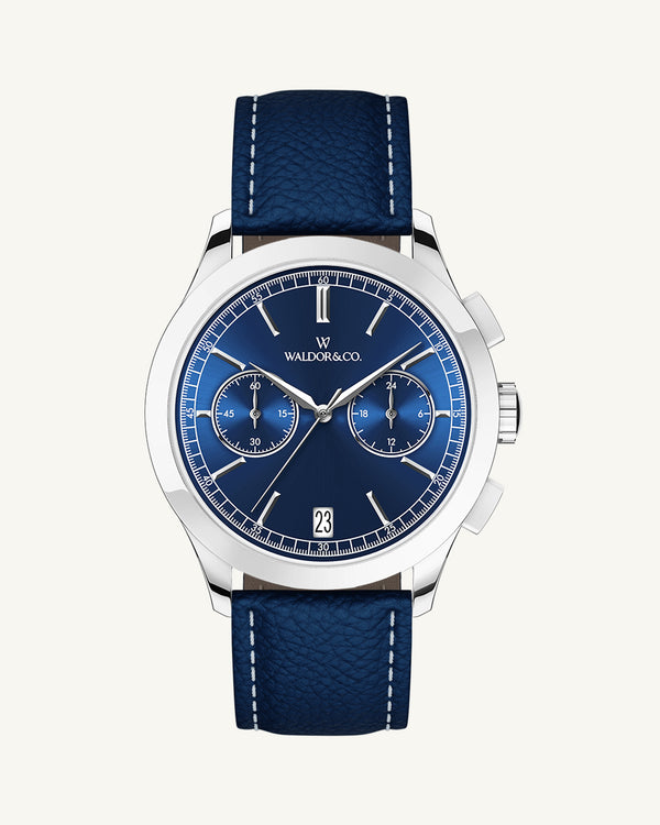 A round mens watch in rhodium-plated silver from Waldor & Co. with blue sunray dial and genuine blue leather strap. A second hand. Seiko movement. The model is Chrono 44 Sardinia 44mm.