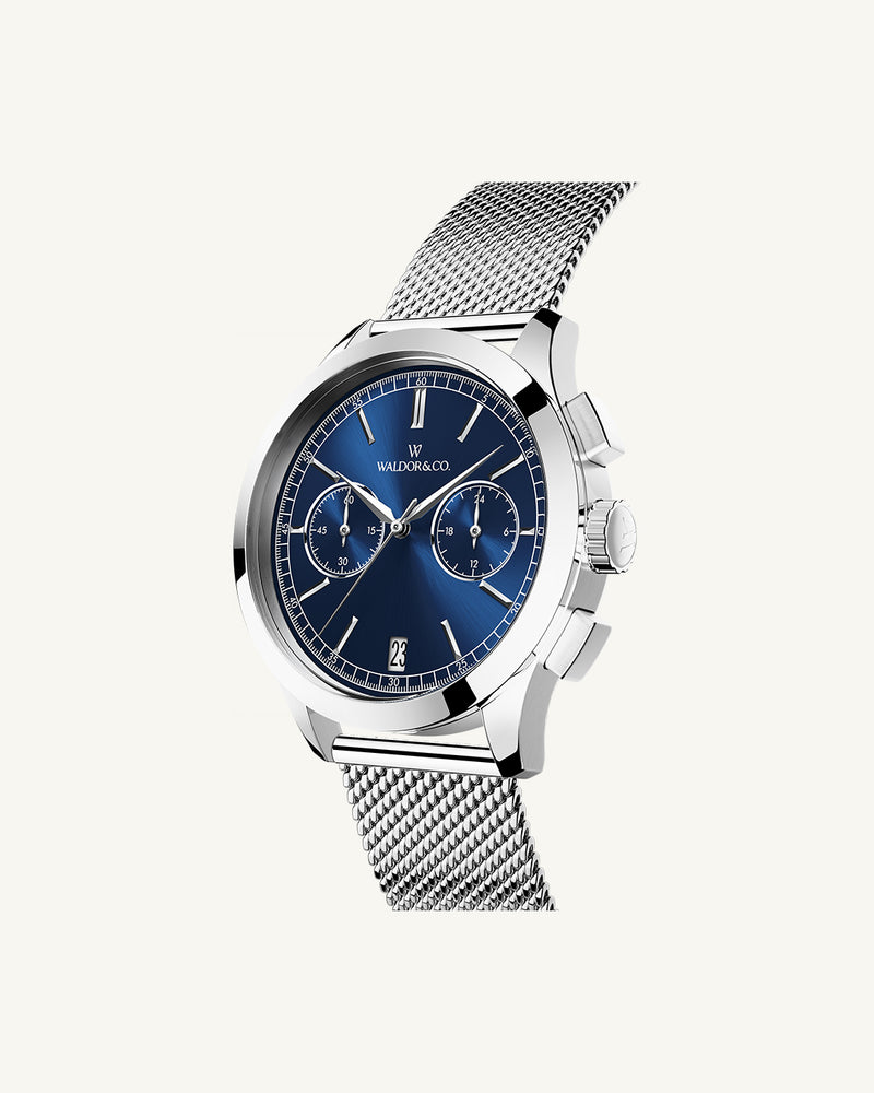 En rund herrklocka i rodiumpläterat silver från WALDOR & CO. med blå sunray urtavla och en sekundvisare. Seiko urverk. Modellen är Chrono 44 Sardinia 44mm. 