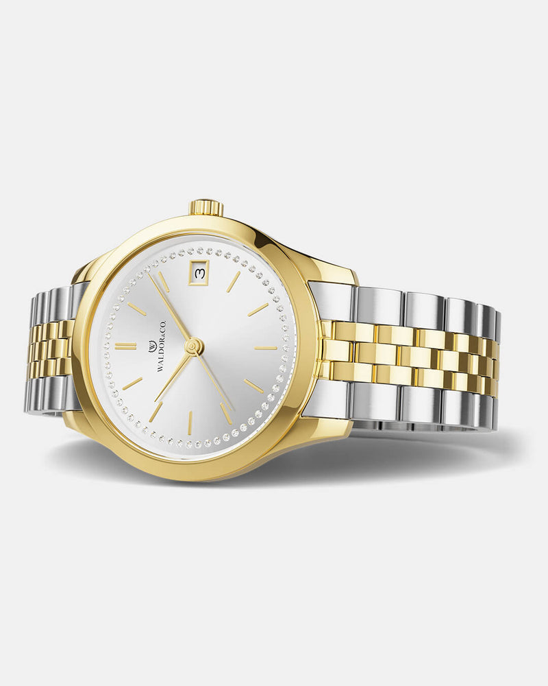 A round womens watch in 14k gold from Waldor & Co. with silver sunray dial and a second hand. Seiko movement. The model is Imperial 36 Roma 36mm.